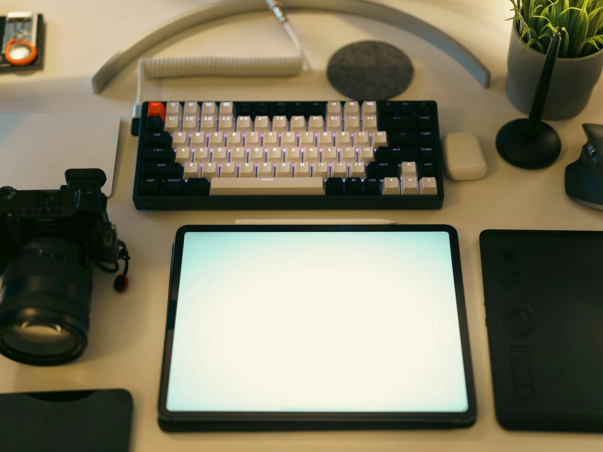 A modern desk with laptop, camera, and technology accessories